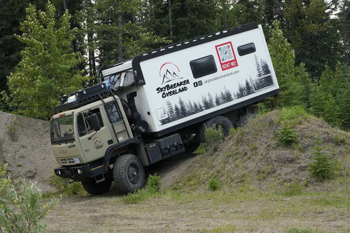Skybreaker Overland Acela 6x6 expedition truck climbing a banked gravel slope