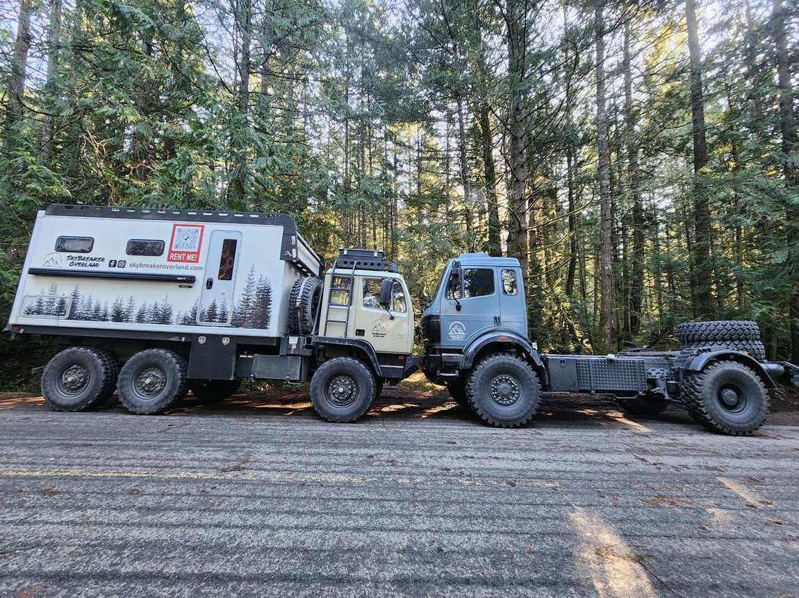 Side profile of Roxanne, the Acela M1088 6x6 expedition truck, on a forest road