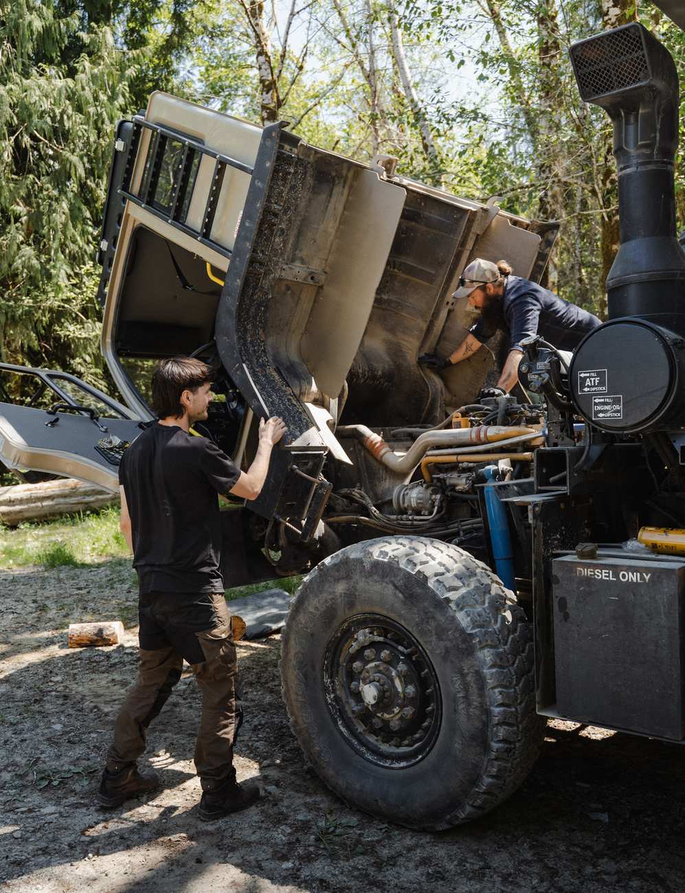 Technician working on the open rear of an expedition truck chassis
