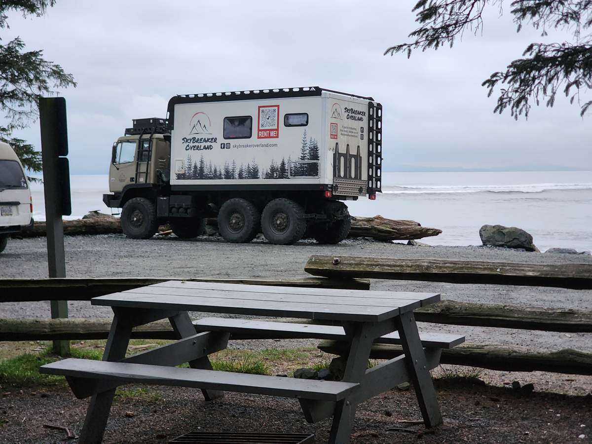 Skybreaker expedition truck parked beside a picnic table on a west coast Vancouver Island beach