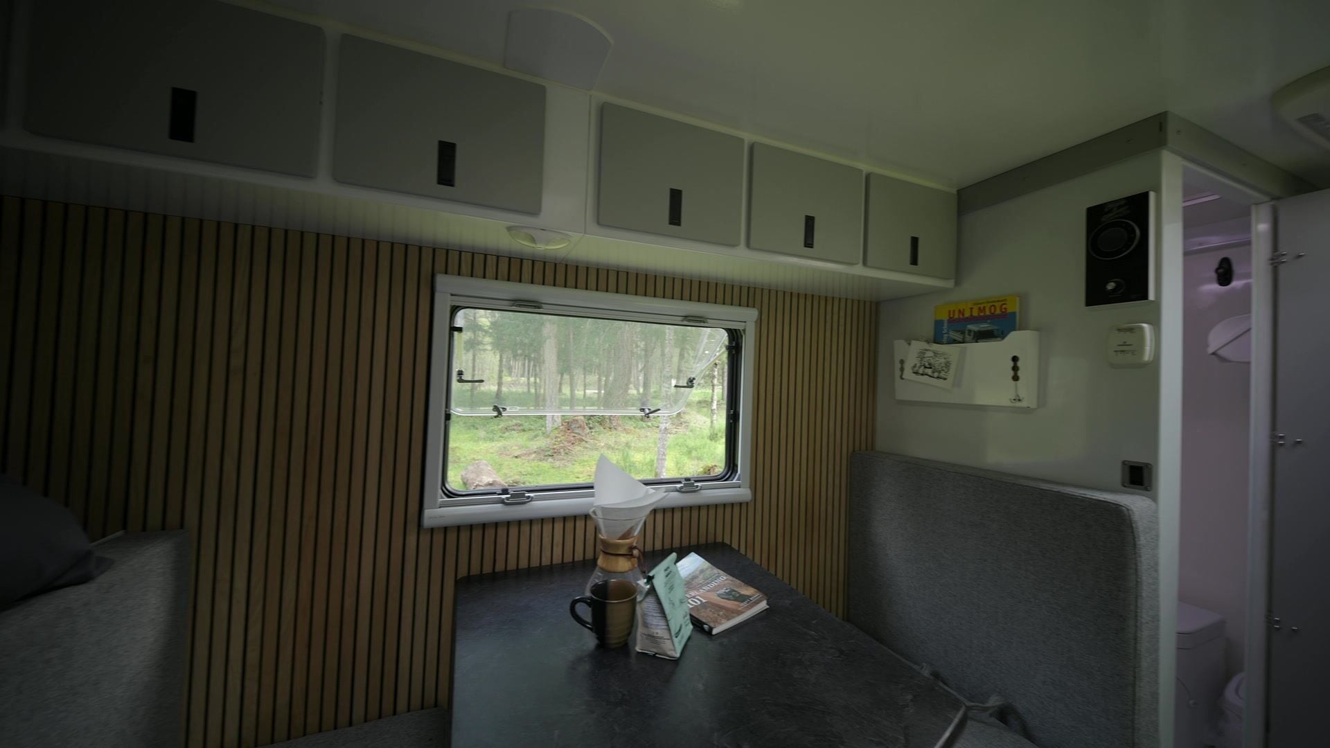 Roxanne's dinette table and bench seat beside the window, open onto forest